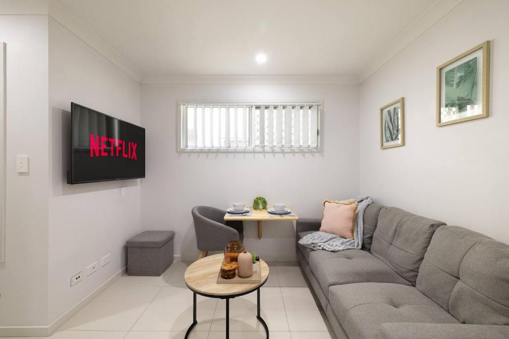 a living room with a couch and a table at Smart Suites Self Check-in Apartments - S Freney in Brisbane