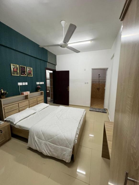 a bedroom with a bed and a ceiling fan at شقة البشائر in Al Khawḑ
