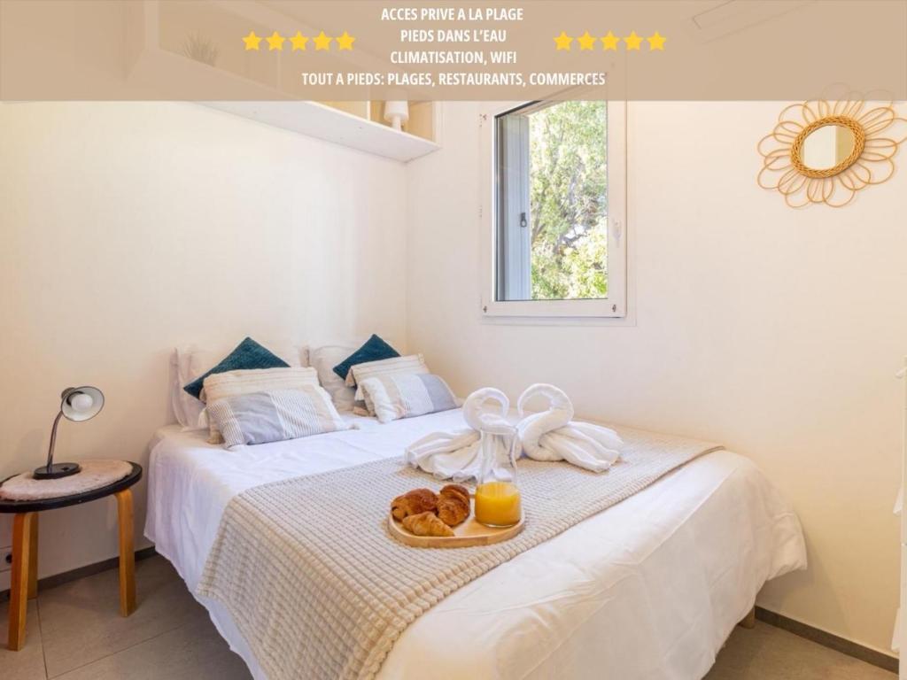 Un dormitorio con una cama con un plato de comida. en Pied dans l Eau Cosy Sablettes Clim WiFi, en La Seyne-sur-Mer