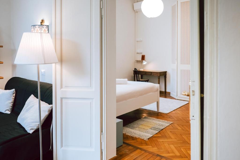 una habitación con una cama y un sofá y una lámpara en SM Hospitality MONTE PASUBIO, en Reggio Emilia