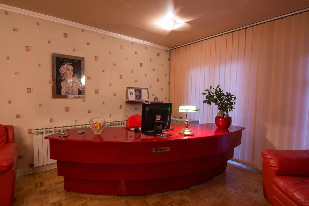 een woonkamer met een rood bureau met een computer erop bij Accommodation Zara in Vukovar
