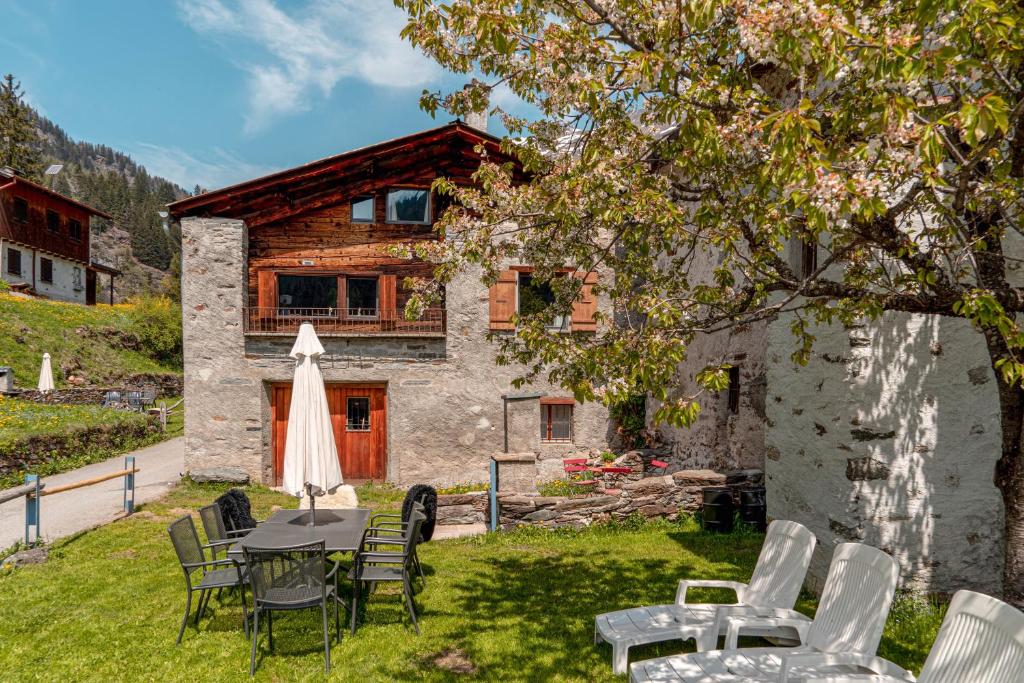a table and chairs in front of a house at Sunny, rustical 5 room cottage in Valposchiavo in Poschiavo
