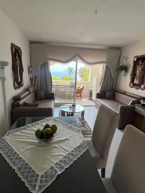 a living room with a table with a bowl of fruit on it at Sea View Apartment with Full kitchen and living room in Sharm El Sheikh