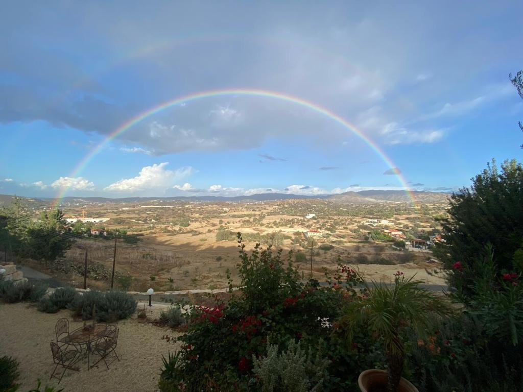 a rainbow in the sky over a field at Endless Sunset in Pendakomo