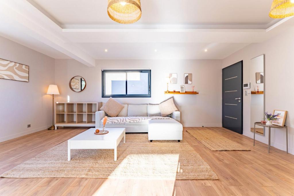 ein Wohnzimmer mit Sofa und Tisch in der Unterkunft La maison Barthe design 4ch clim parking privé in Toulouse