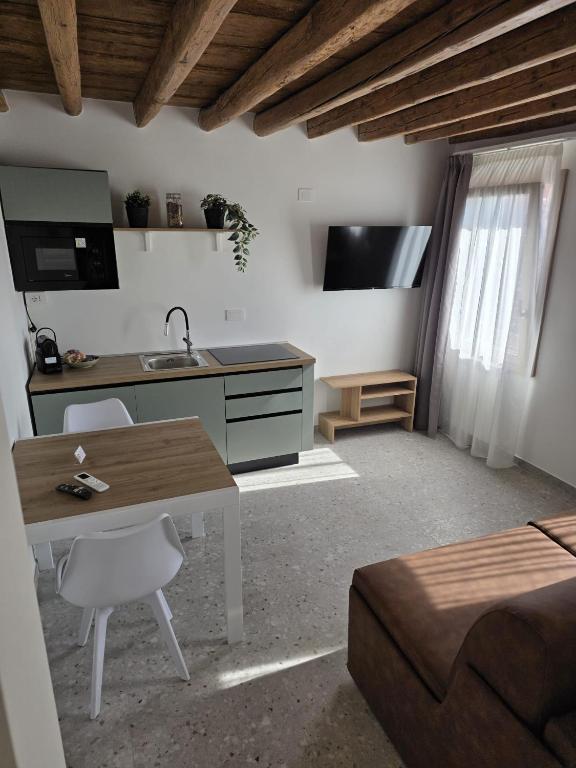 a kitchen and living room with a table and a sink at Dimora Muneghette 181 by ApartSuite in Chioggia
