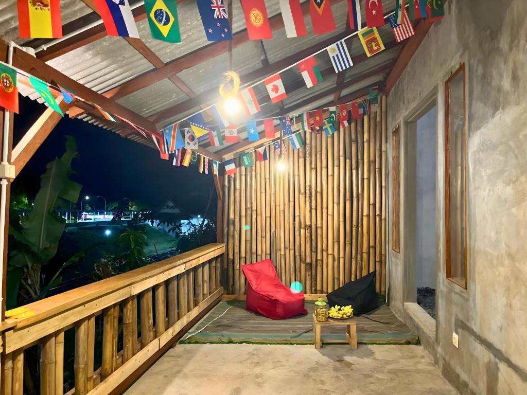 un porche avec des drapeaux et une table sur un balcon dans l'établissement Ijen Backpacker Atas Angin dekat Stasiun Banyuwangi Kota, à Giri
