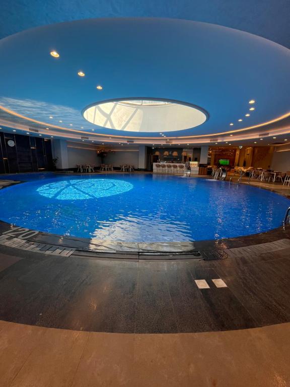 a large swimming pool in a building with a blue ceiling at Jw Marriott residence in Cairo
