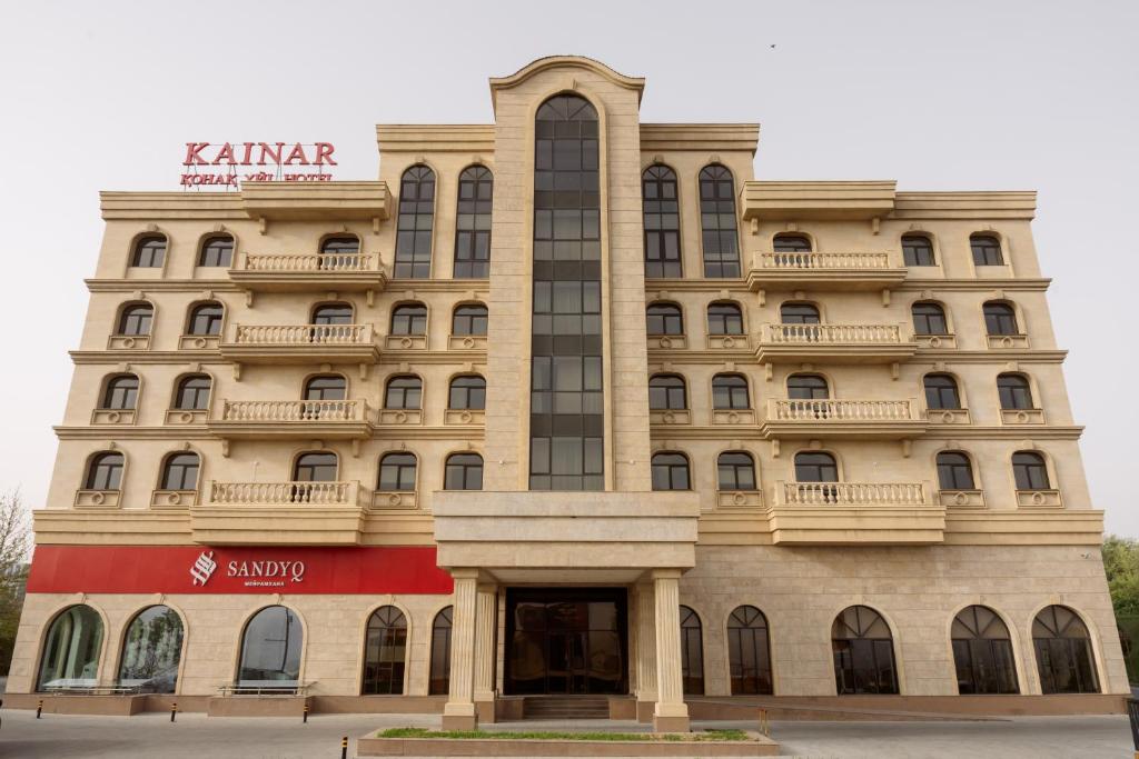 シムケントにあるKainar Hotelの上に看板がある建物