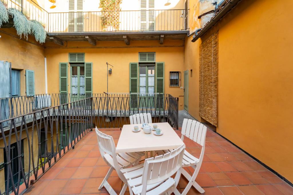 a patio with a table and chairs on a balcony at La Terrazza in Centro Storico - Free Wifi & AC in Savigliano