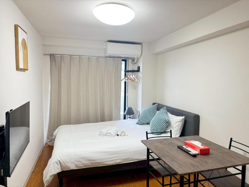 a small bedroom with a bed and a table at Nogata House in Tokyo