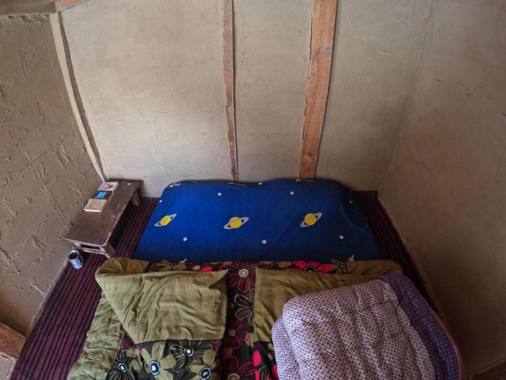 Habitación pequeña con cama y maleta en Cliff Seek, en Kalgha