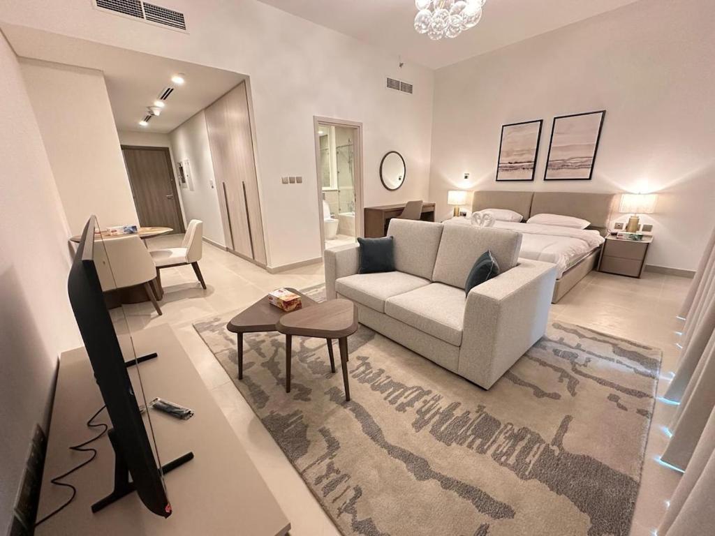a living room with a bed and a couch and a tv at HARF310 Modern Studio w Balcony at Yas Island in Abu Dhabi