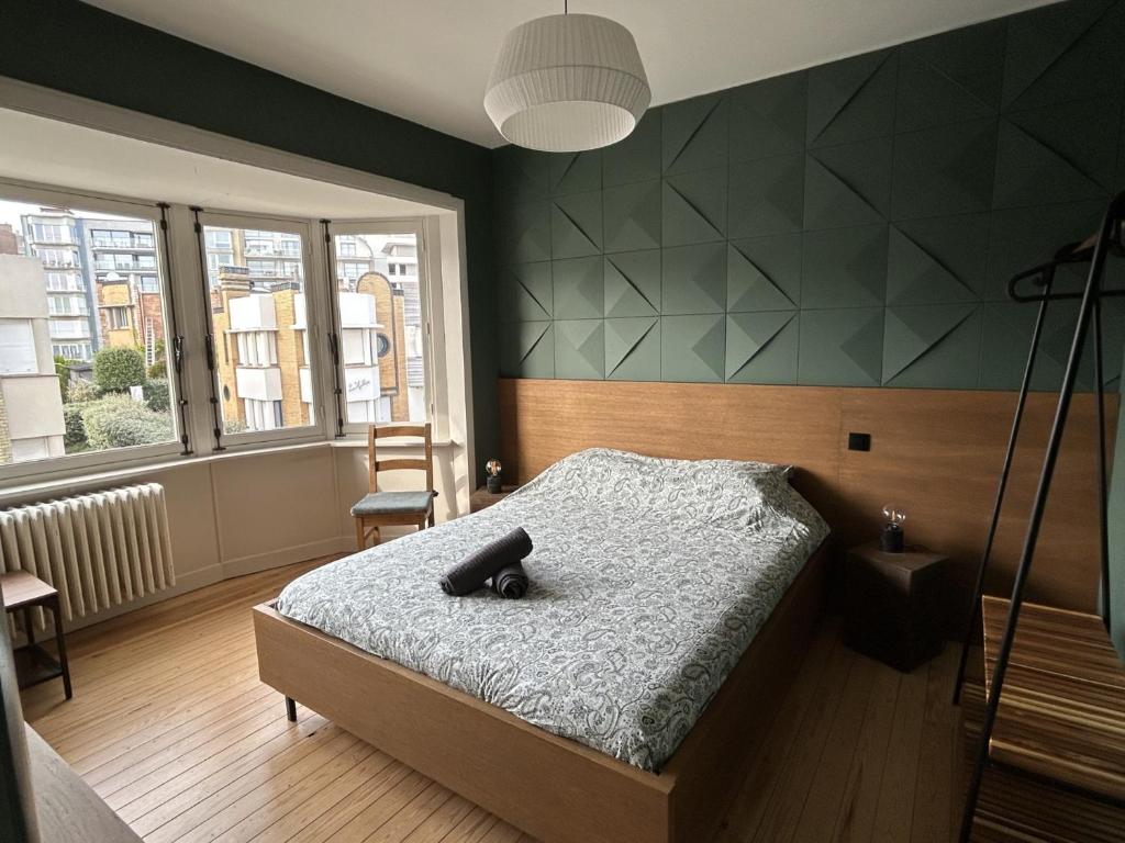 - une chambre dotée d'un lit avec un objet noir dans l'établissement -Le bel abri- à 2 pas de la mer, à La Panne