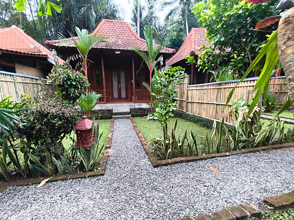 a house with a garden in front of it at Pondok Bali Koempi in Ubud
