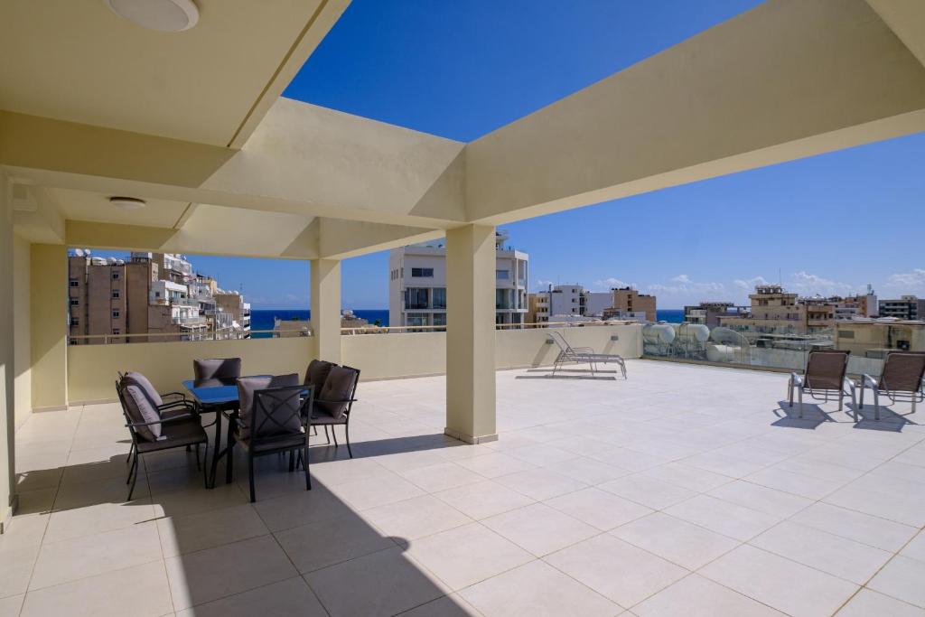 a patio with chairs and a table on a roof at Downtown Sea View Penthouse in Larnaca