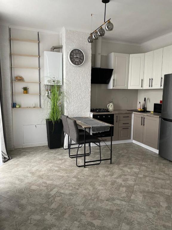 a kitchen with white cabinets and a table in it at Авторский in Fontanka