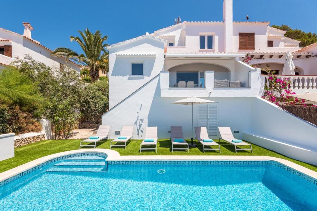 a villa with a swimming pool and a house at Villa Marnes by Menorca Vacations in Son Bou