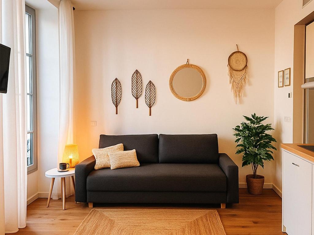- un salon avec un canapé noir et un miroir dans l'établissement Modern apartment with AC near Old Nice & Beach, à Nice