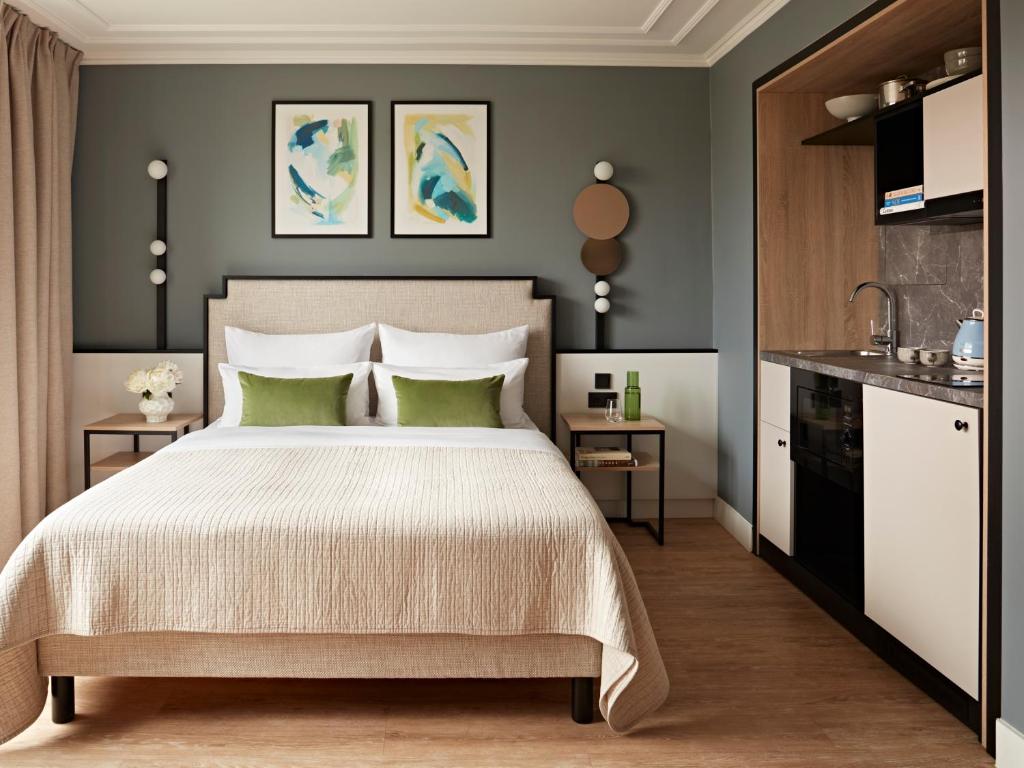 Un dormitorio con una cama grande con almohadas verdes. en Numa Berlin Arc, en Berlín
