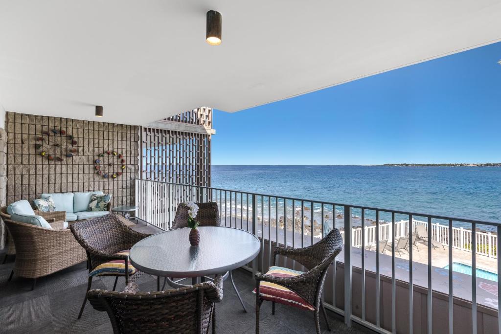 a balcony with a table and chairs and the ocean at Alii Villas #230 condo in Kailua-Kona
