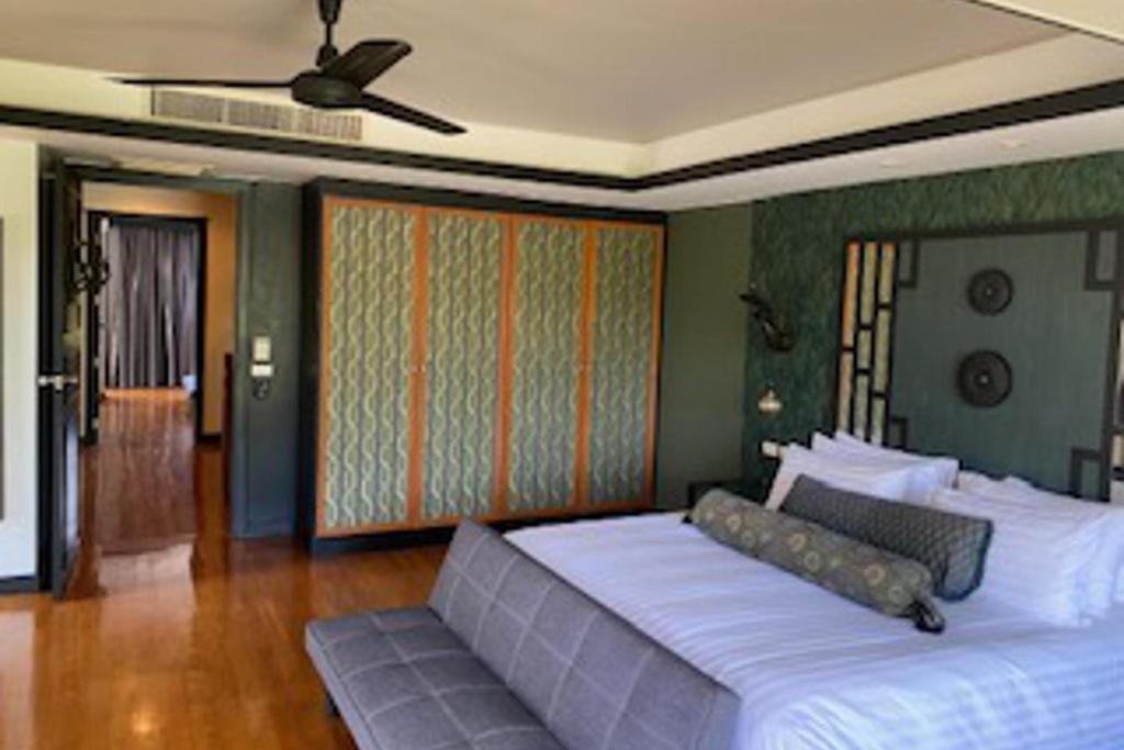 a bedroom with a large bed and a couch at 2Bed Villa - Sleeps 4 - Poolside Wifi Near Beach in Layan Beach
