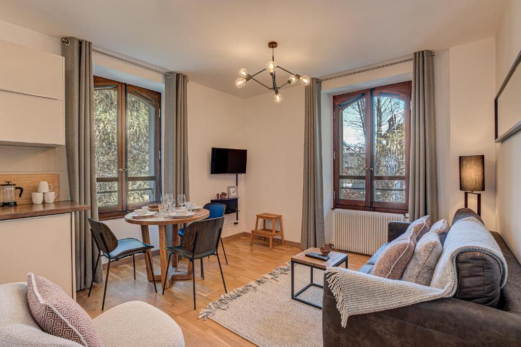 una sala de estar con un sofá y una mesa en Apartment La Roseraie - Alpes Travel - Central Chamonix (sleeps 2-3), en Chamonix-Mont-Blanc