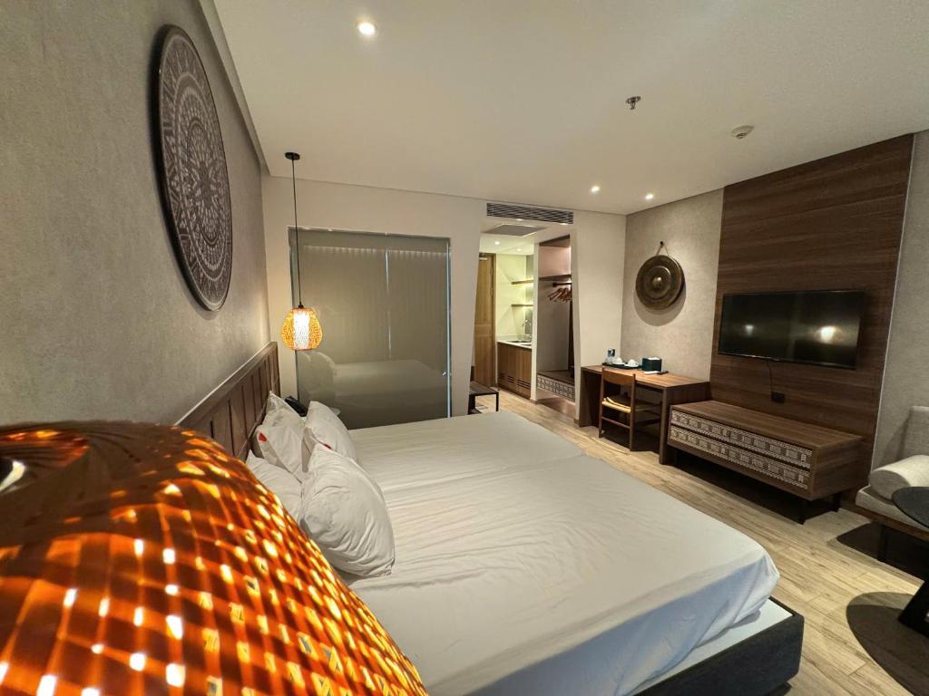 a bedroom with a large bed and a television at Min Min Retreat in Phước Hậu