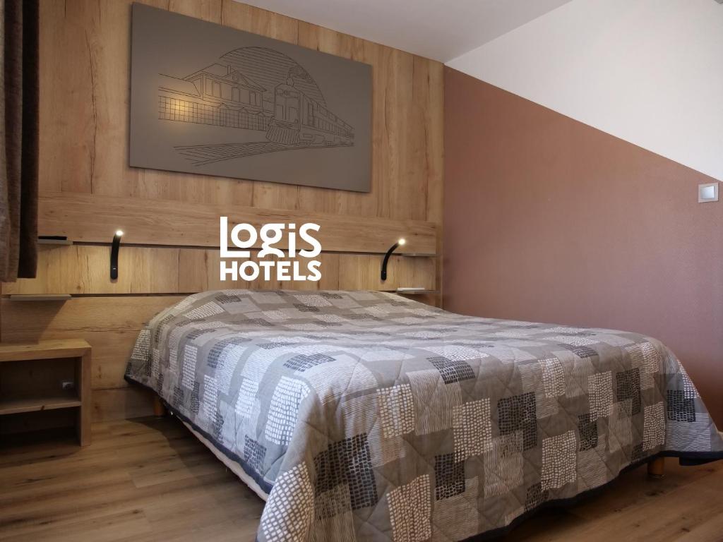 a bedroom with a bed with a sign on the wall at Logis Hotel de la Gare in Saint-Mihiel