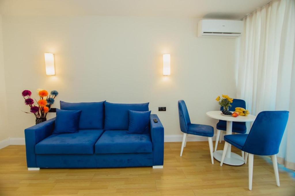 a living room with a blue couch and a table at Orbi City Premium Sea View Apartments in Batumi