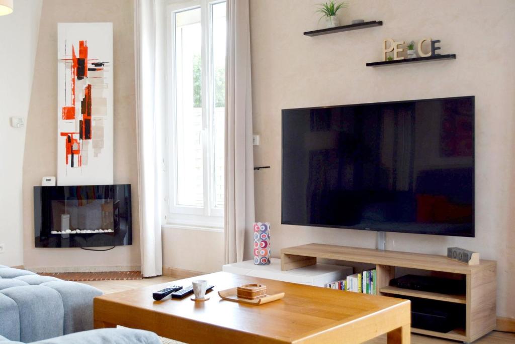 Una sala de estar con un televisor de pantalla plana grande. en La Milena, en Morancez