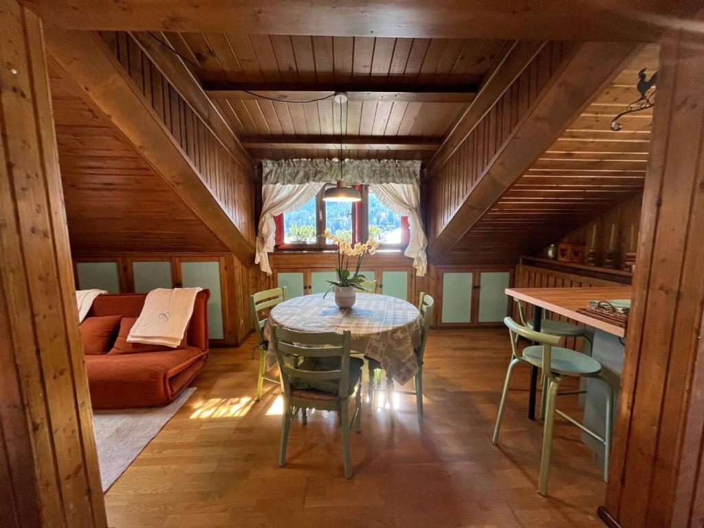 a dining room with a table and a couch at Renovated Mountain View Appartment in Auronzo di Cadore