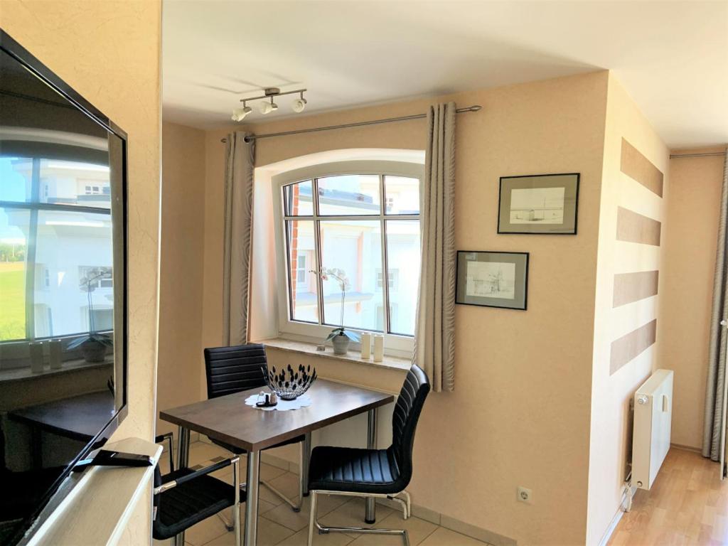 a dining room with a table and chairs and a window at Seewind 6 in Cuxhaven