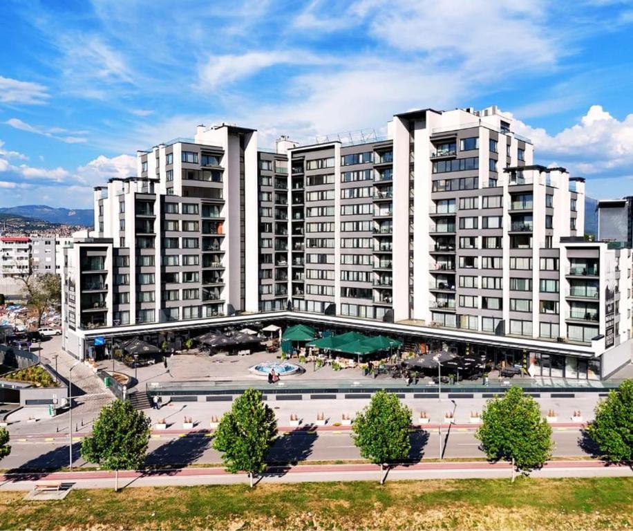 a large building with a courtyard in front of it at River Walk Sarajevo in Sarajevo