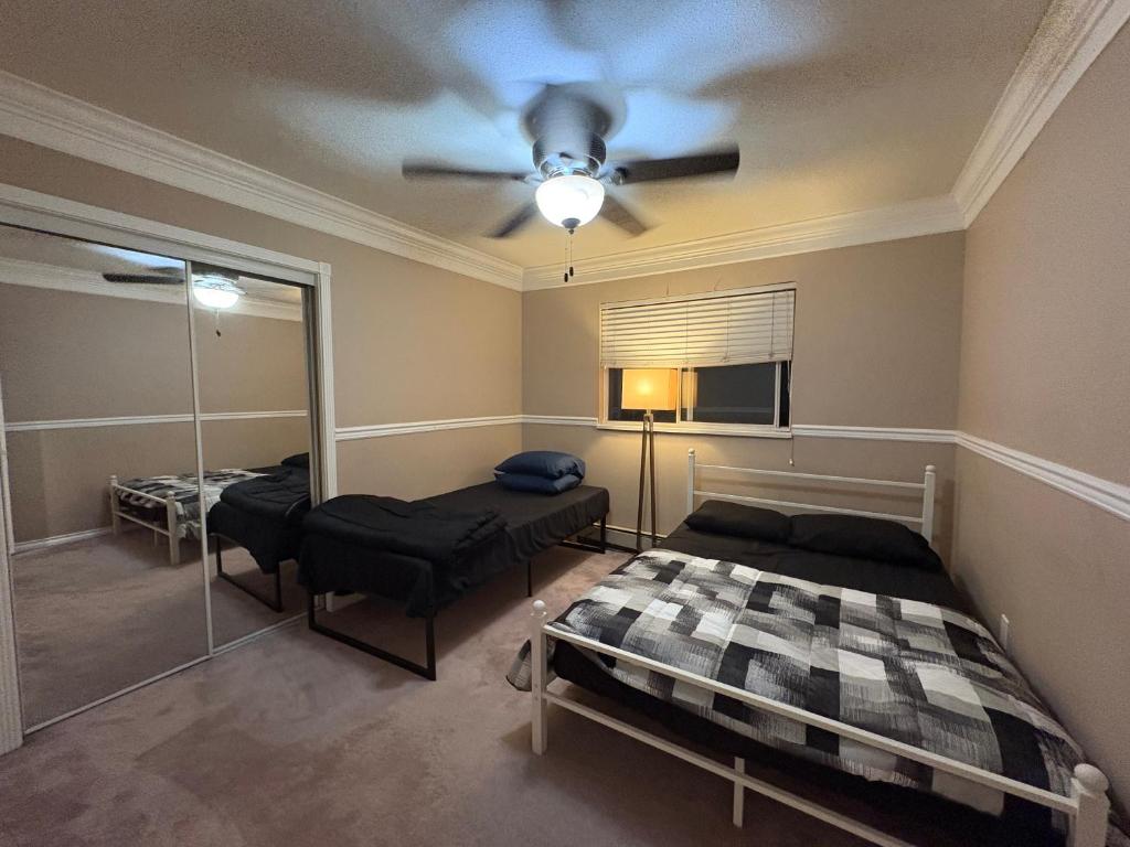 デルタにあるPrivate Room Near Transit, Shopping, High Speed Wi-Fi, Parkingのベッド2台と天井ファン付きの寝室