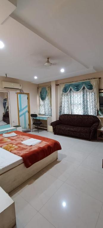 a large bedroom with a bed and a couch at Hotel Swaagat in Agra