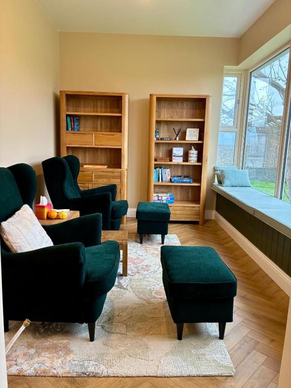 a living room with green furniture and a window at LAKE VIEW Luxury Apartment in Dunfanaghy