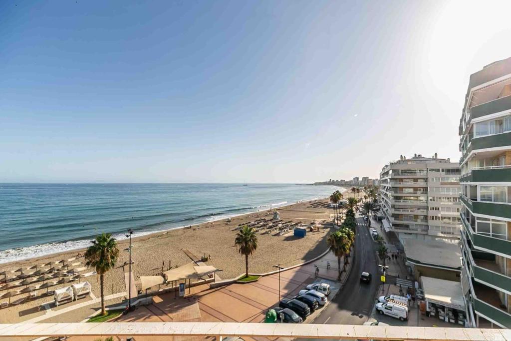 a view of a beach with palm trees and buildings at Apartamento Calypso in Las Lagunas Mijas