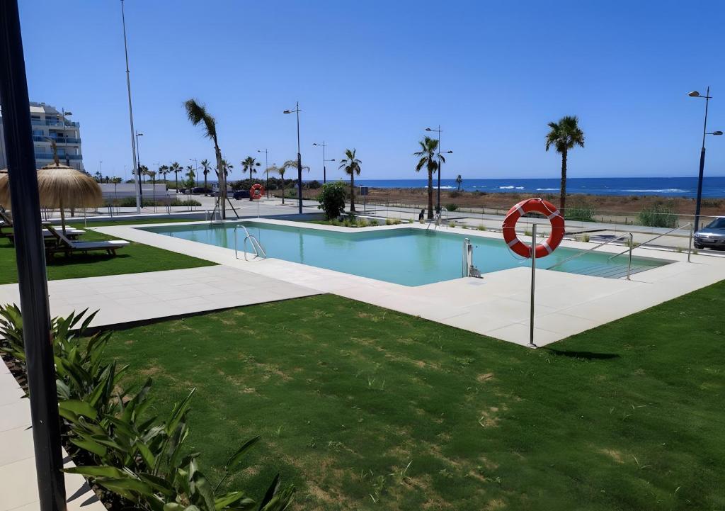 a swimming pool with a red life ring next to the beach at Paraiso Duna 2 Beach Views in Morche