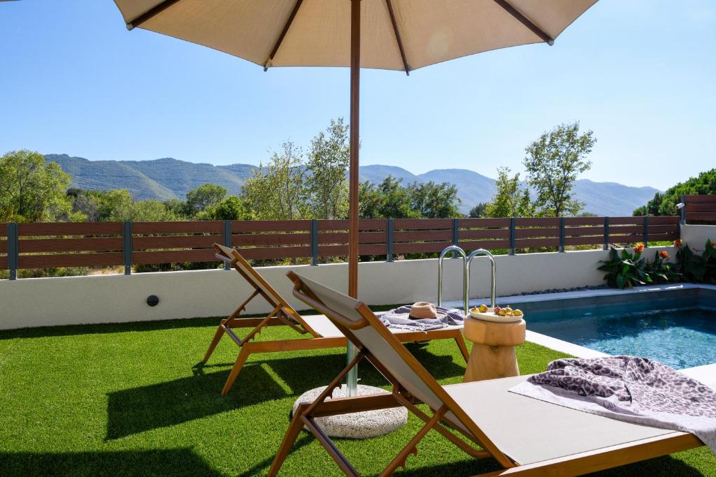 a patio with a table and chairs and an umbrella at Golden Gaia 