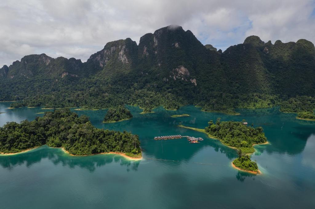 an island in the water with mountains in the background at 360 issara Floating Resort in Ban Chieo Ko