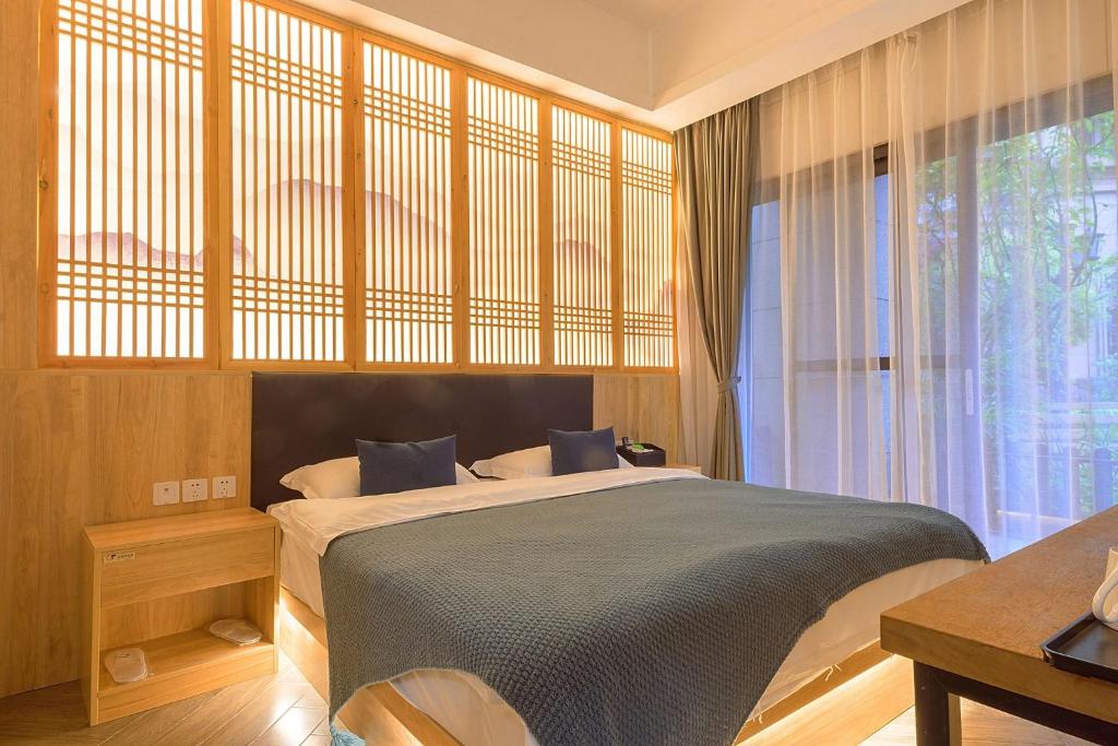 a bedroom with a large bed and a window at Heinemann Hotel courtyard or terrace king room A108 with a jacuzzi and a local in Baoguosi