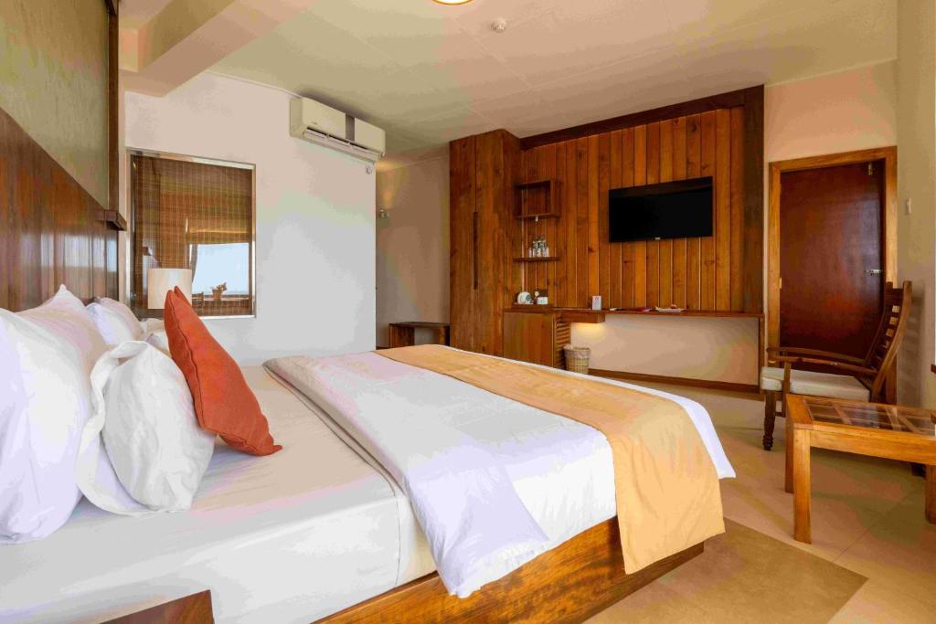 a bedroom with a large bed and a television at Insight Resort Ahangama in Ahangama