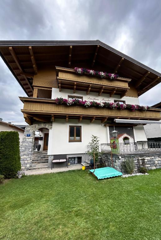 a house with a balcony with flowers on it at Appartment Marcher in Kaprun