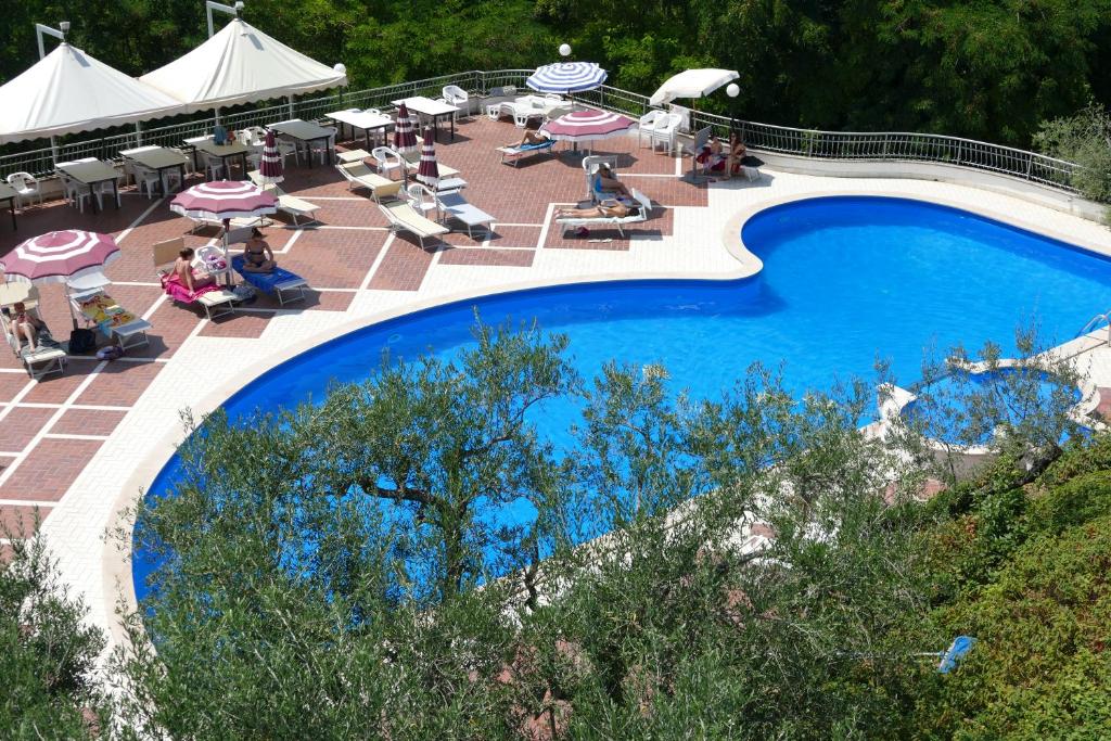 - une vue sur la piscine bordée de chaises et de parasols dans l'établissement Hotel L'Ulivo, à Mirabella Eclano