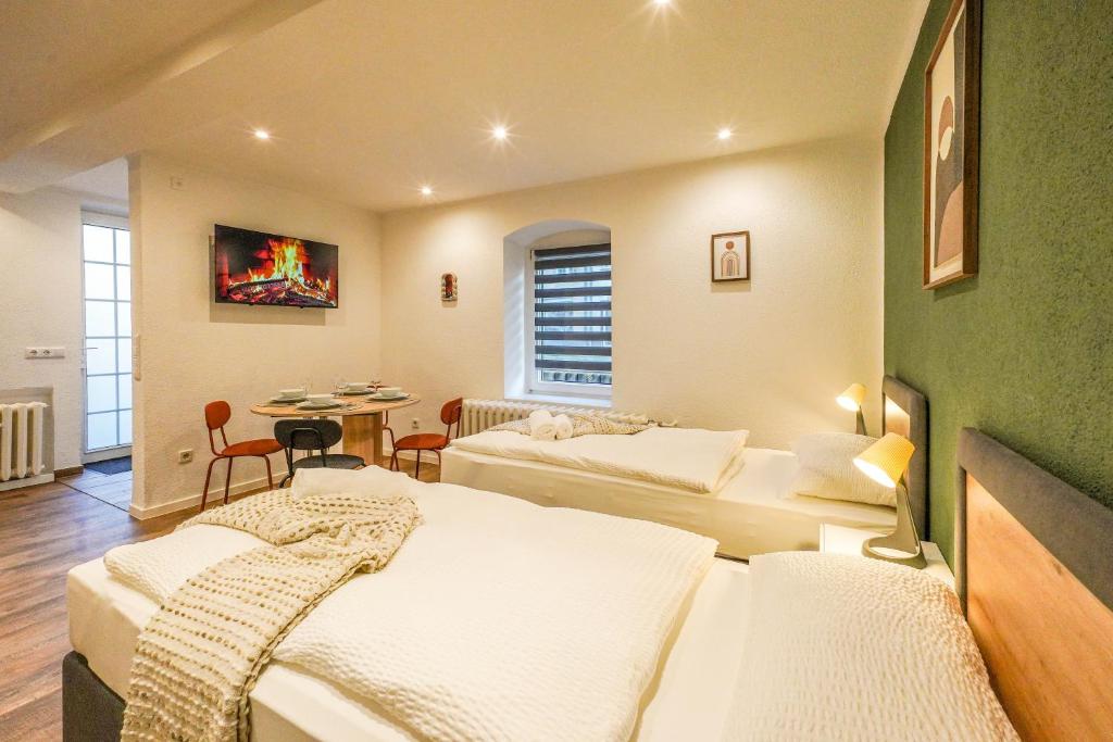 a hotel room with two beds and a table at BaLa Suites Apartment House in Bad Lausick