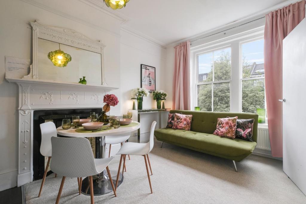 a living room with a green couch and a table at Boutique Accommodation in London