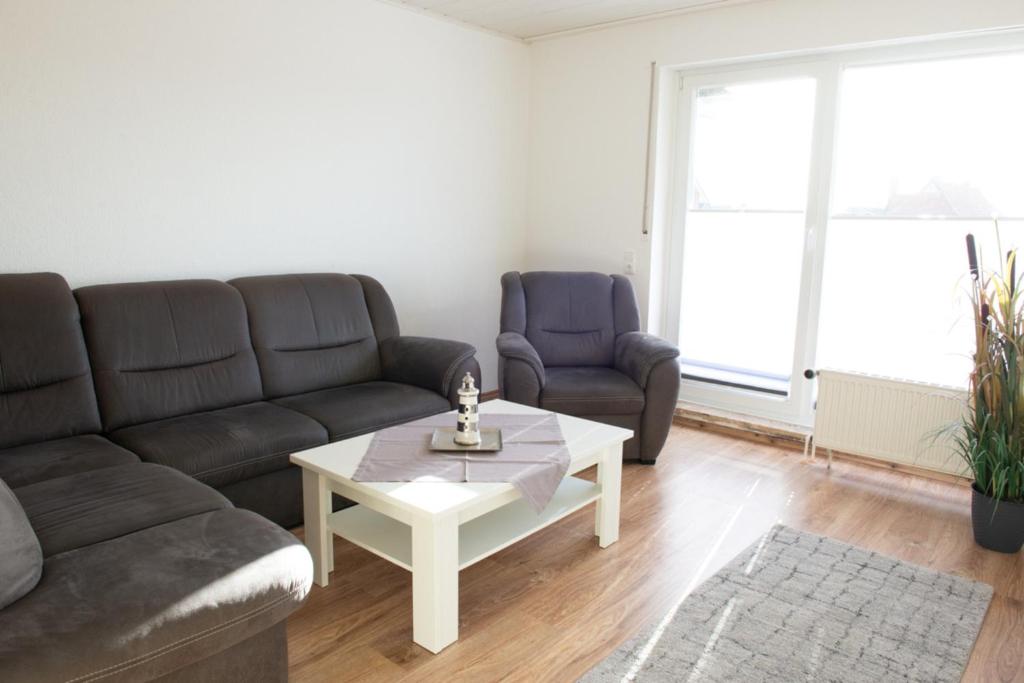 a living room with a couch and a coffee table at Deichnähe F in Norddeich