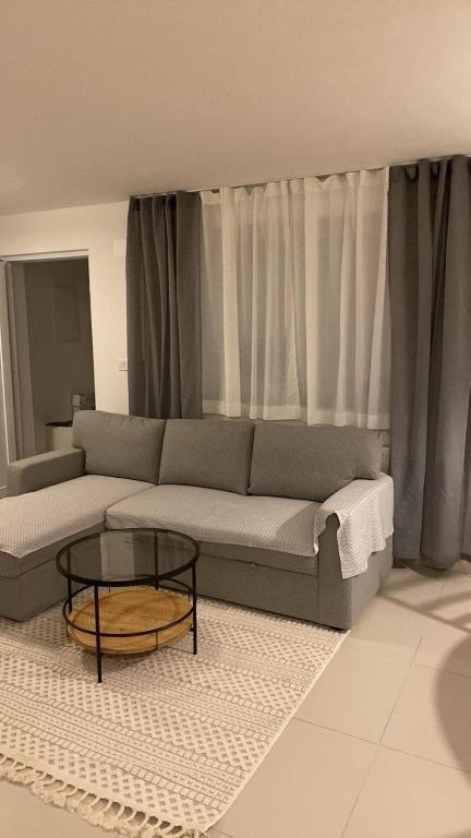 a living room with a couch and a glass table at Apartman Turić Vinkovci in Vinkovci