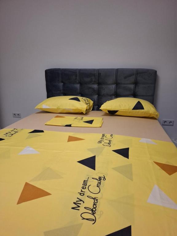 a bed with a comforter with writing on it at Apartman Ditka in Bihać